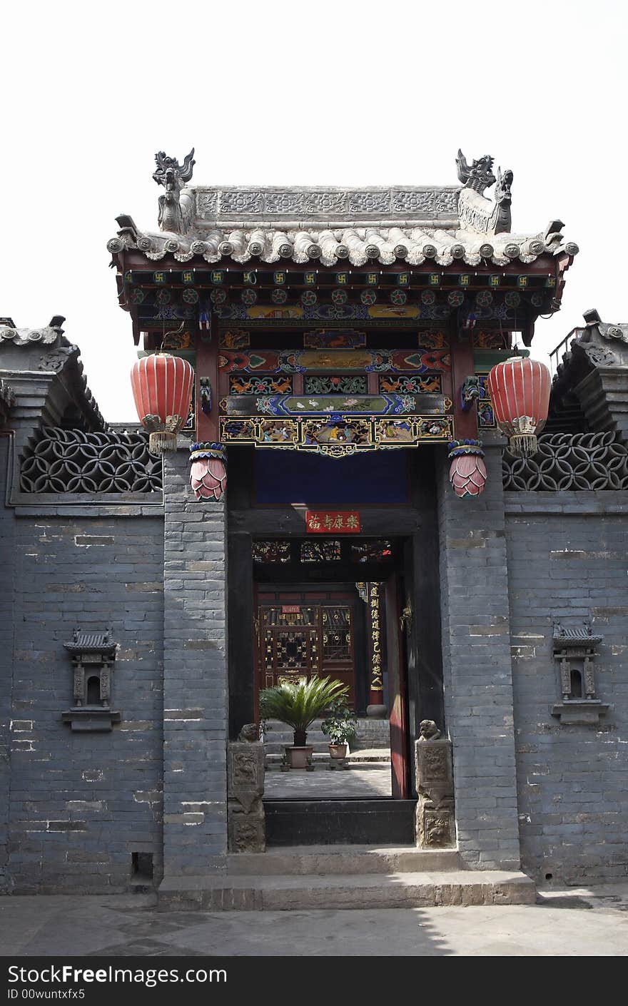 Front door of the old house of China.This is the typical building in period of Ming and Qing. Both sides at gate,unless it enshrine and worship temple of land, last temple and language of offering against god of land above Chinese.. Chinese on two banners on the door means blessings are and lucky. Chinese on the column is China's ancient poesy in the courtyard!