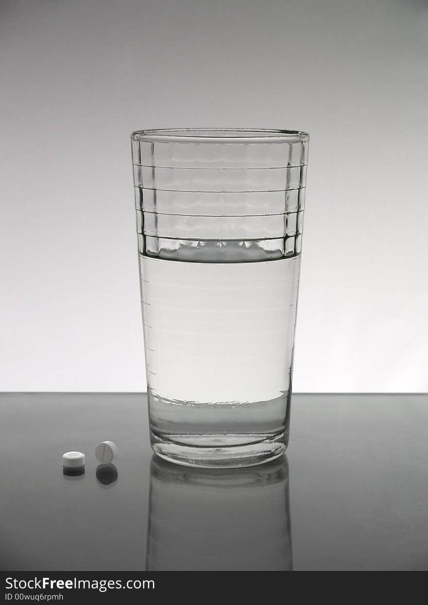 A glass of water with two pills