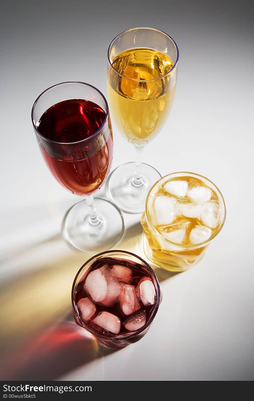 Beautiful glasses with wine and a cocktail on a white background