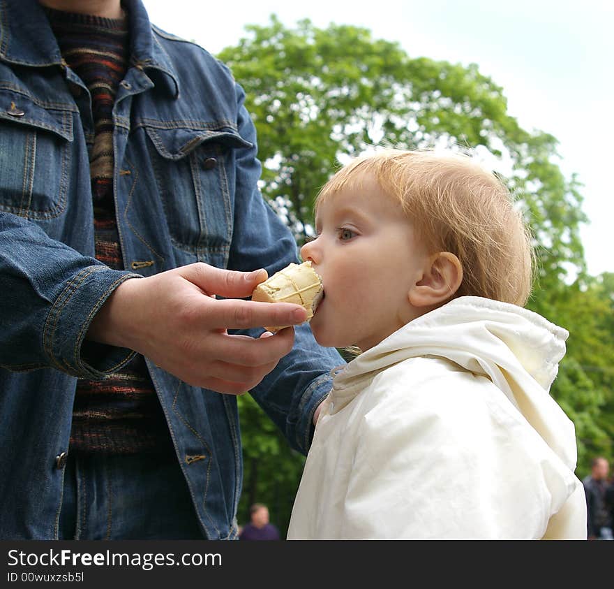 Daddy gives to daughter ice-cream near a fountain. Daddy gives to daughter ice-cream near a fountain