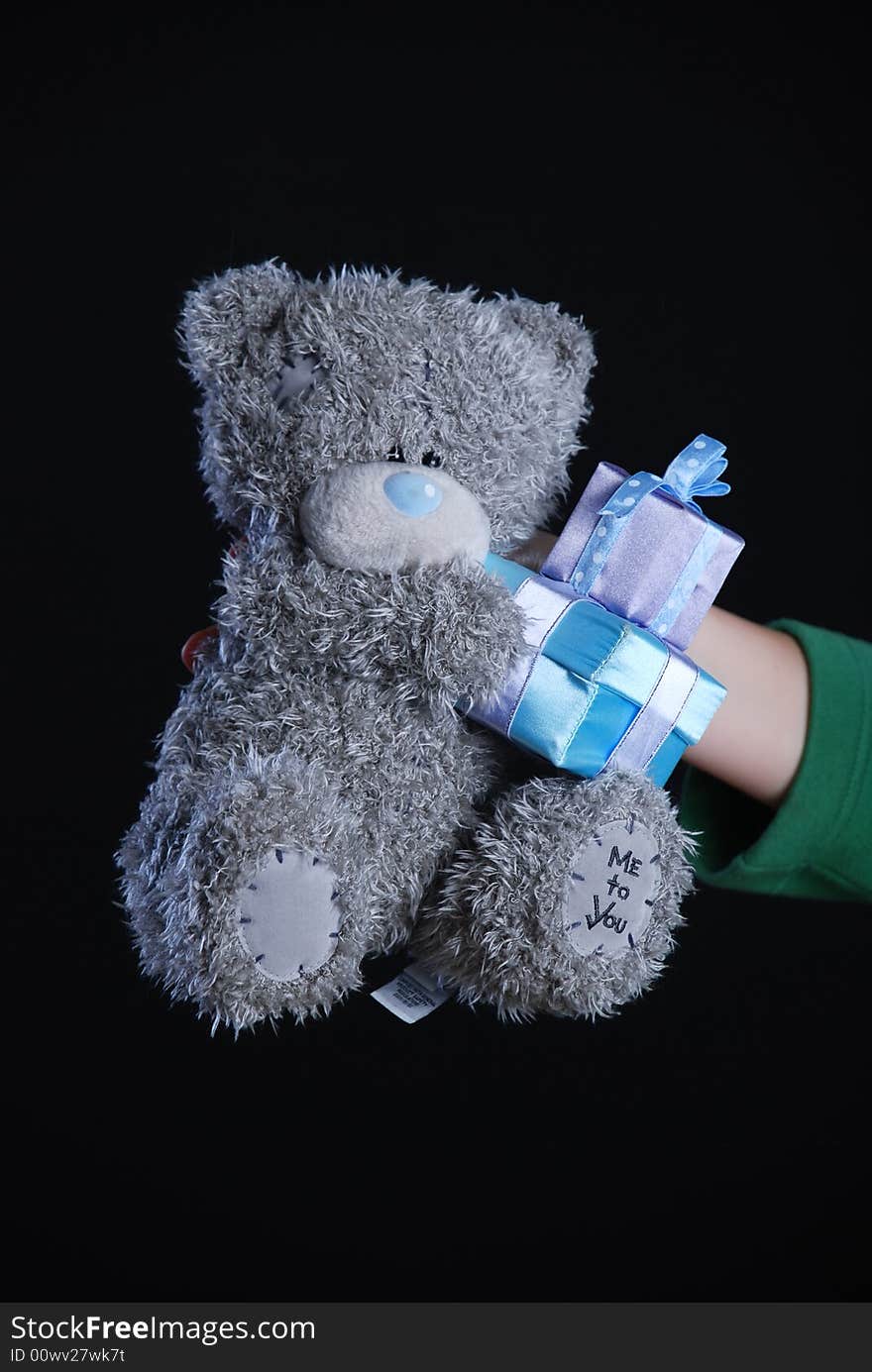 Teddy bear in hand at black background