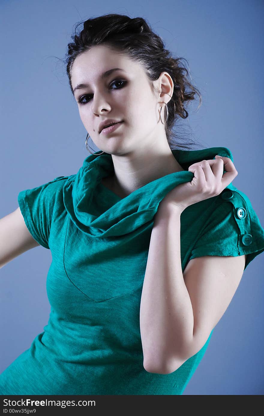 Beauty fashion woman in green clothes at blue background. Beauty fashion woman in green clothes at blue background