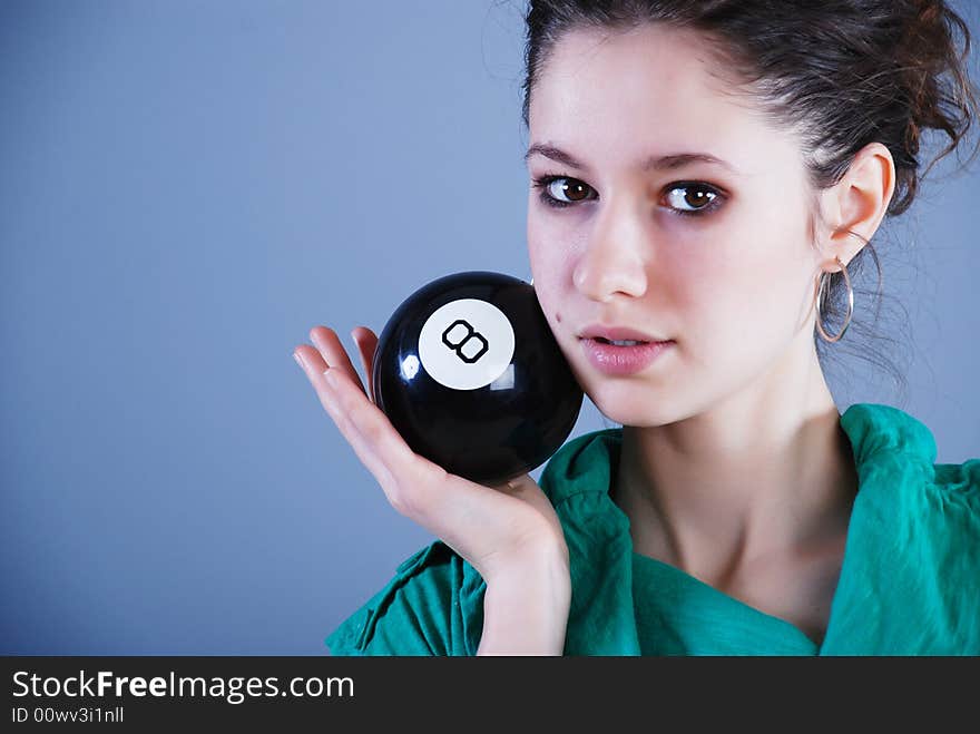 Beauty fashion woman in green clothes at blue background with black ball. Beauty fashion woman in green clothes at blue background with black ball