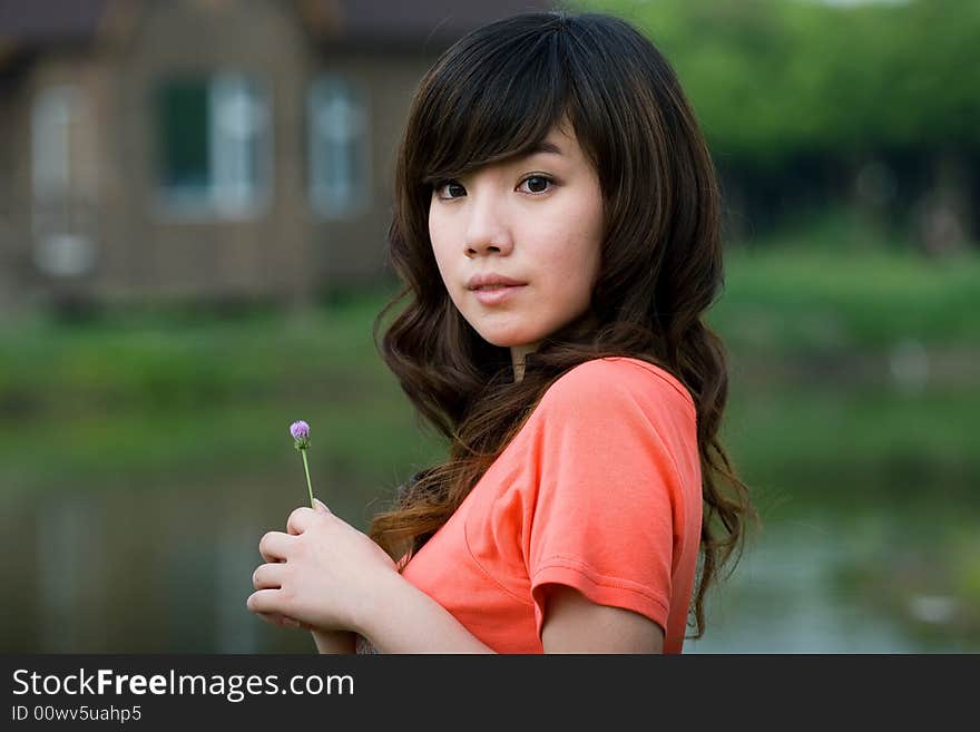 Portrait of young lady holding a little flower