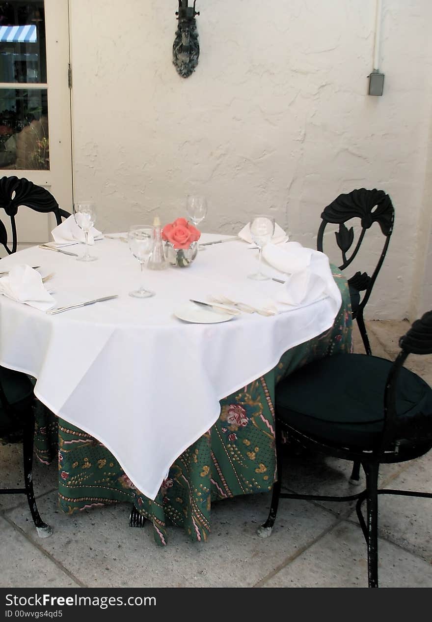 Traditional Table Place Setting with Fresh Pink Roses in Restaurant