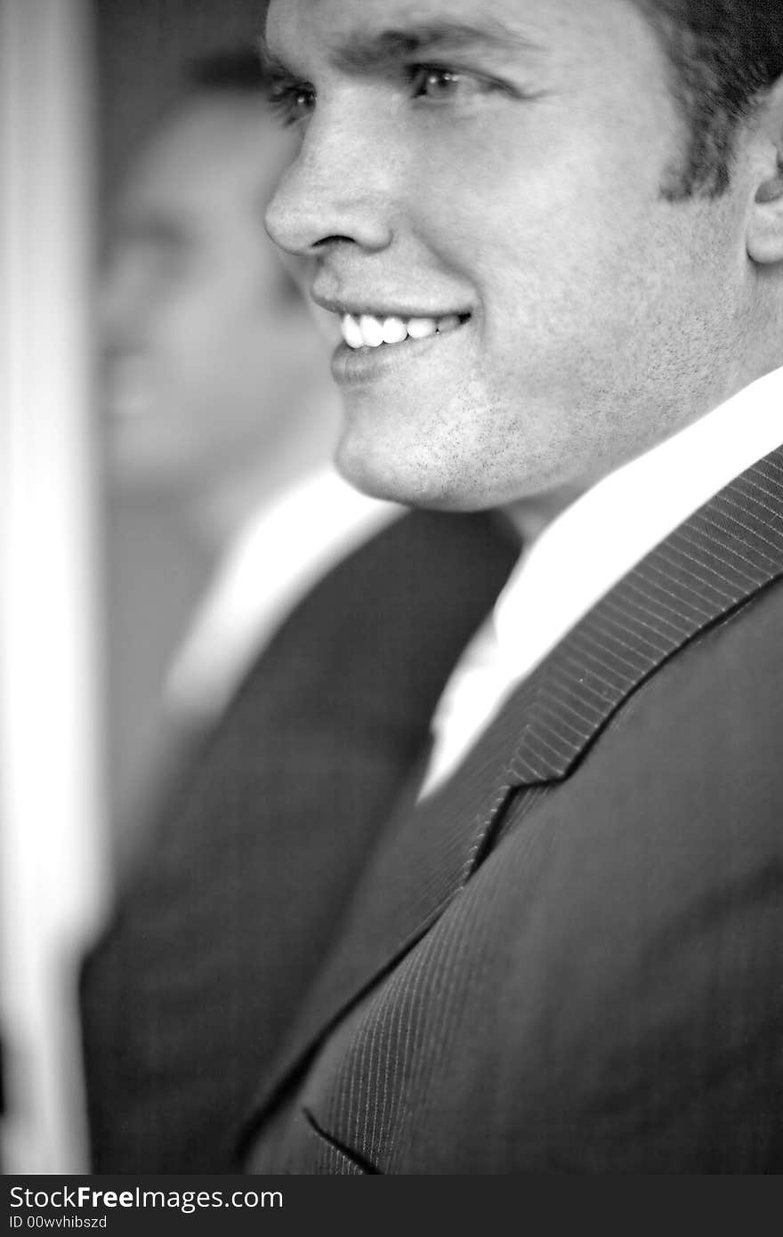 Close up of two businessmen standing, smiling, and wearing suits