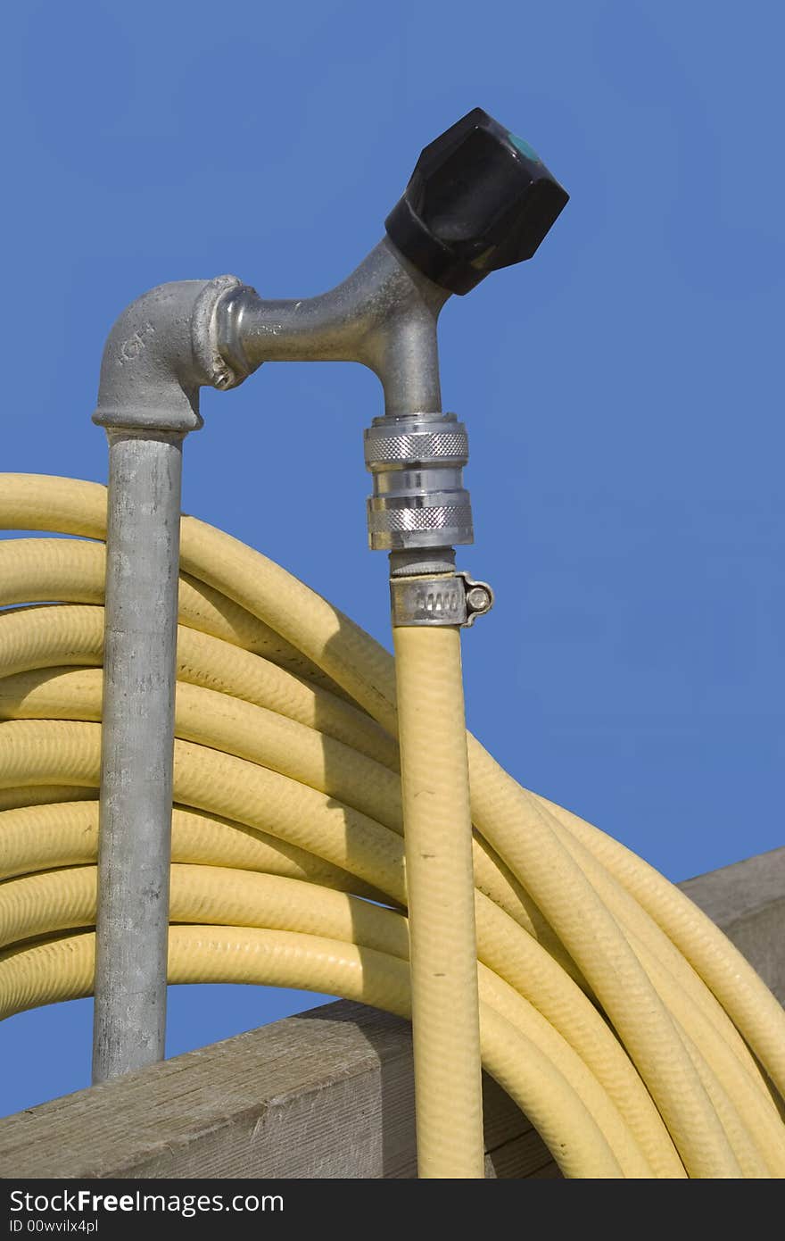 Faucet with a yellow hose for gardening