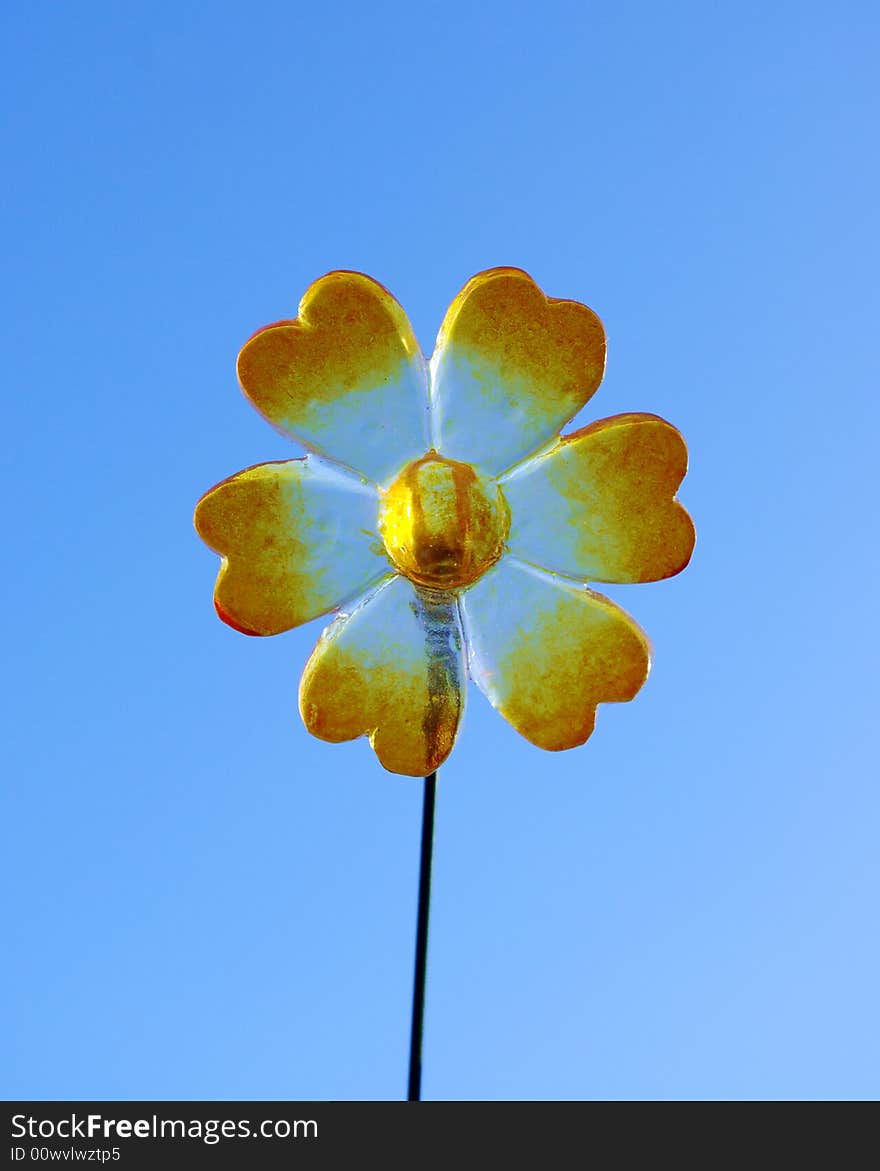 Plastic flower in front of blue sky