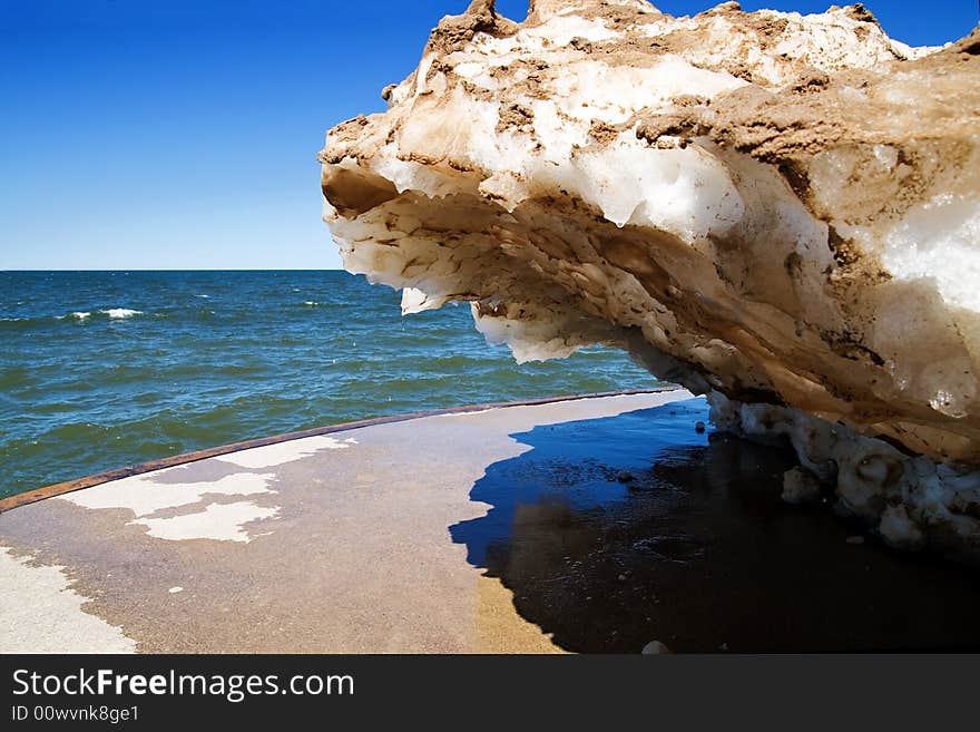 A snow drift, embedded with sand from the harsh winter winds, melts on a warm spring day at a Lake Michigan pier. A snow drift, embedded with sand from the harsh winter winds, melts on a warm spring day at a Lake Michigan pier