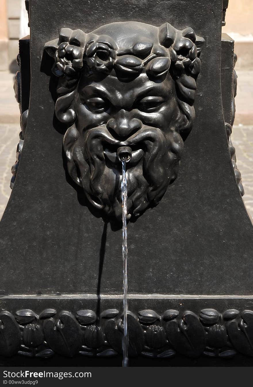 Old,black, iron fountain detail. Classical Greek motive.