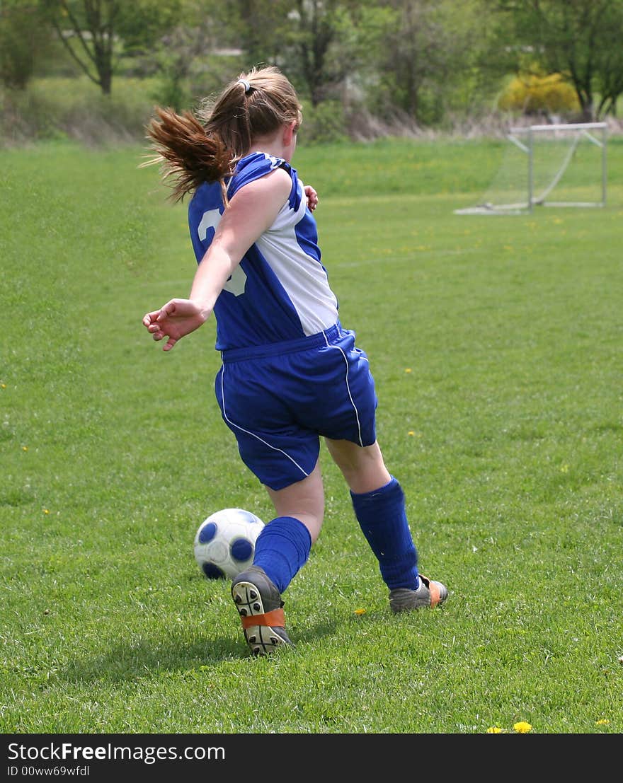 Teen Youth Girls chasing ball down soccer field. Teen Youth Girls chasing ball down soccer field.