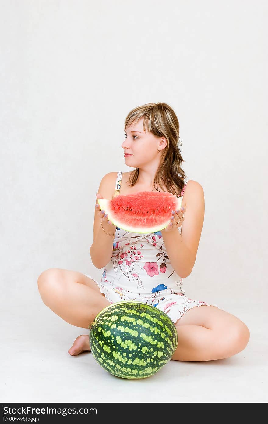 A sitting girl with a water melon in her hands