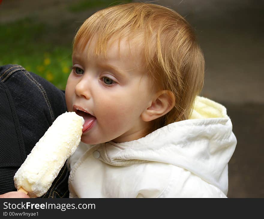 The girl sitting on hands at mum and eats ice-cream. The girl sitting on hands at mum and eats ice-cream