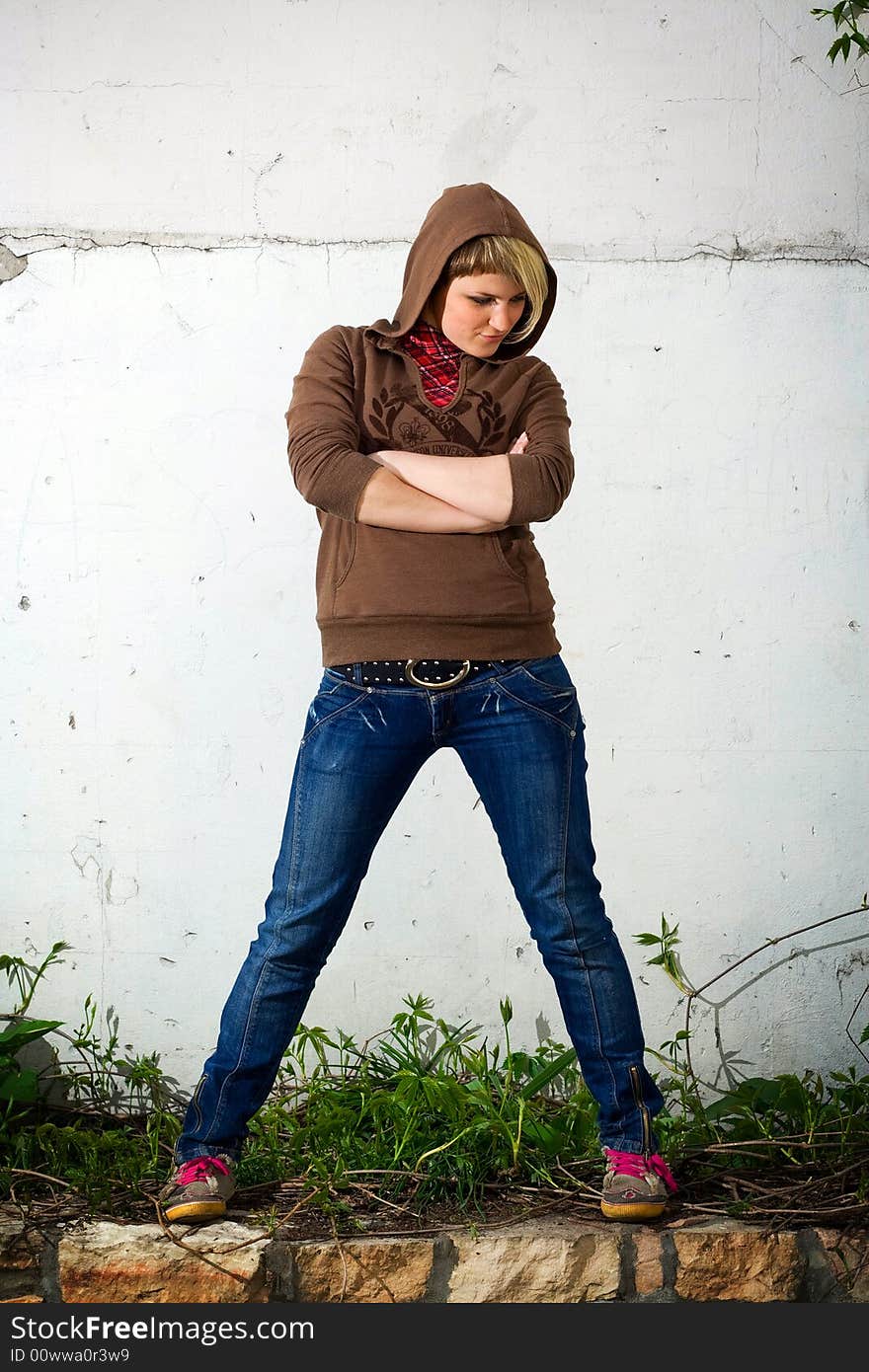 Young girl standing against the wall. Young girl standing against the wall.