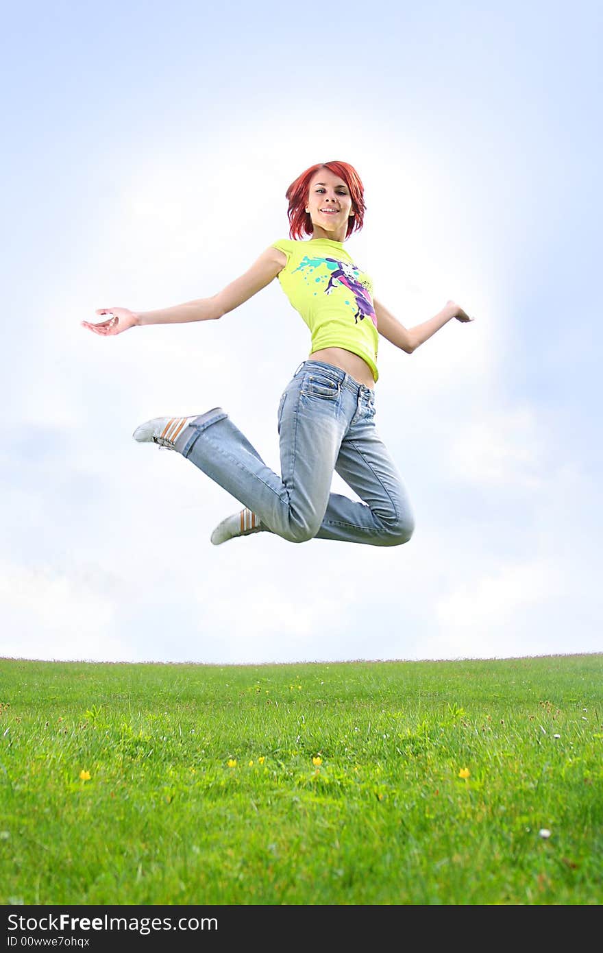 Young redhead girl jumping outdoors. Young redhead girl jumping outdoors