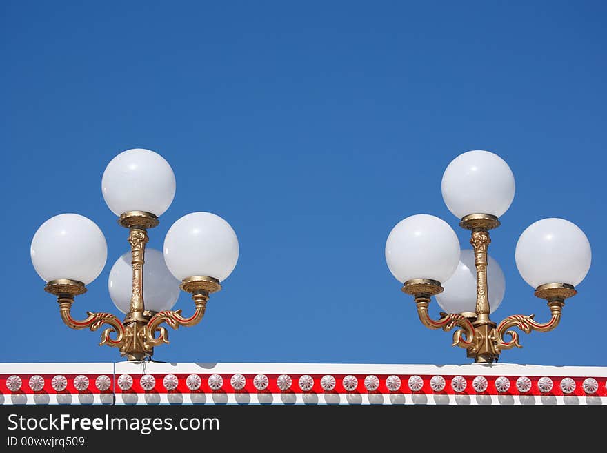 Candelabra at amusement park against blue sky