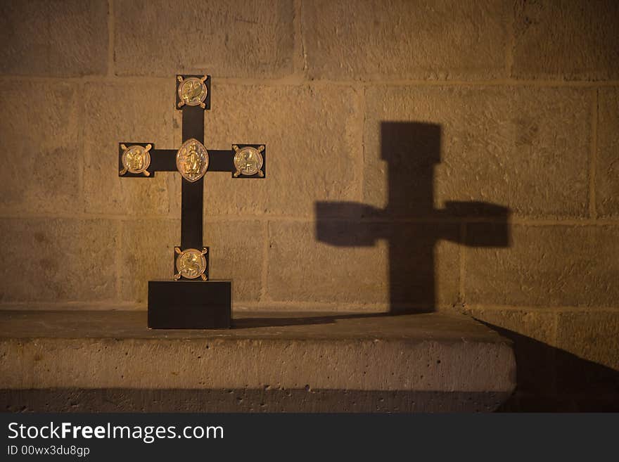 Cross and its shadow in a dark church