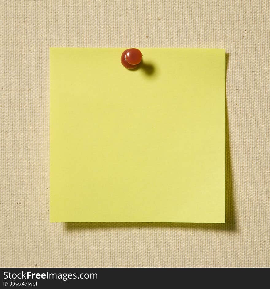 Yellow Note With Red Clip On Brown Textile Background. Yellow Note With Red Clip On Brown Textile Background