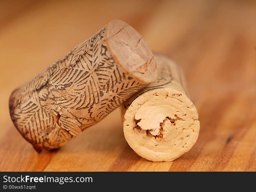 Two Wine Corks Resting On A Wood Surface