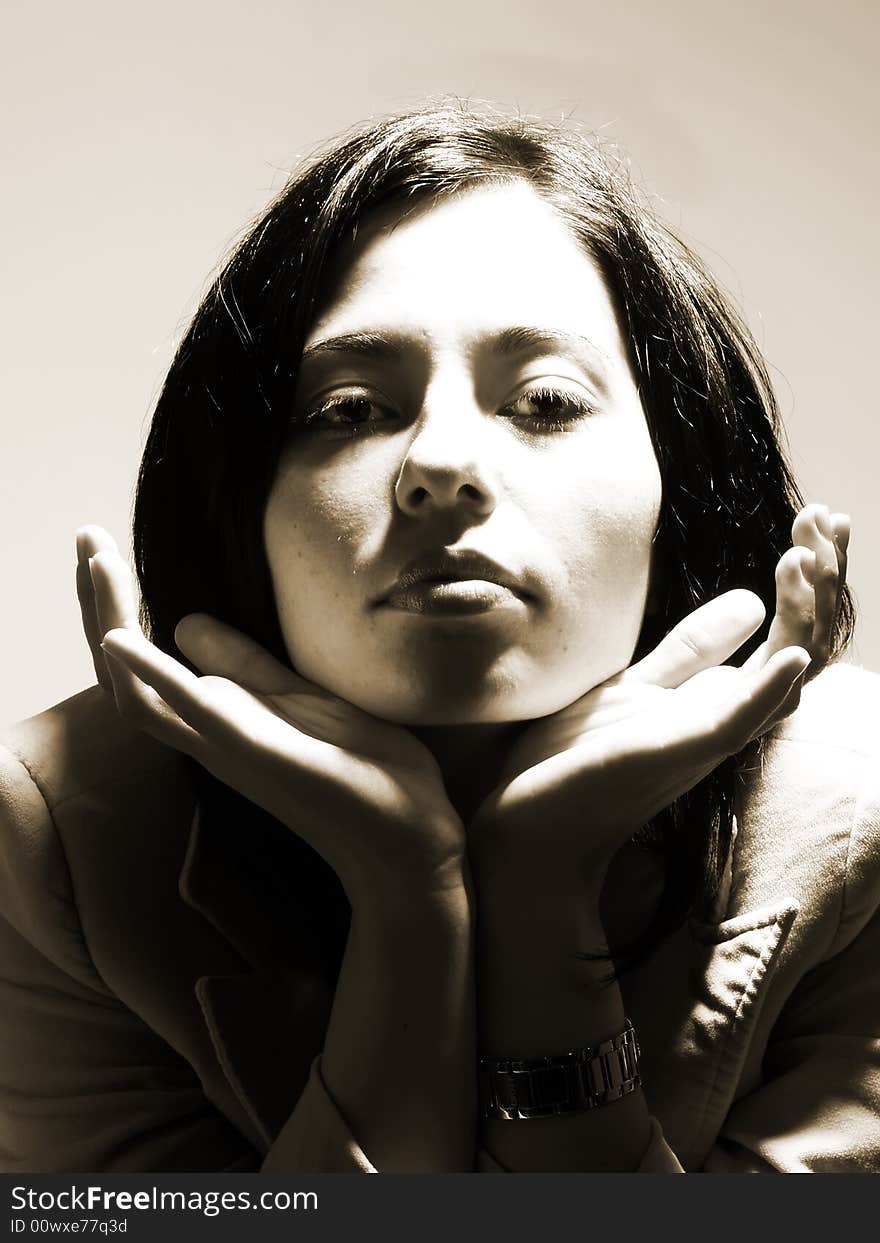 A brownish black and white high-key portrait about a pretty trendy lady with black hair who is spreading her hands, she is sending a kiss and she has a glamorous look. She is wearing a stylish coat. A brownish black and white high-key portrait about a pretty trendy lady with black hair who is spreading her hands, she is sending a kiss and she has a glamorous look. She is wearing a stylish coat.