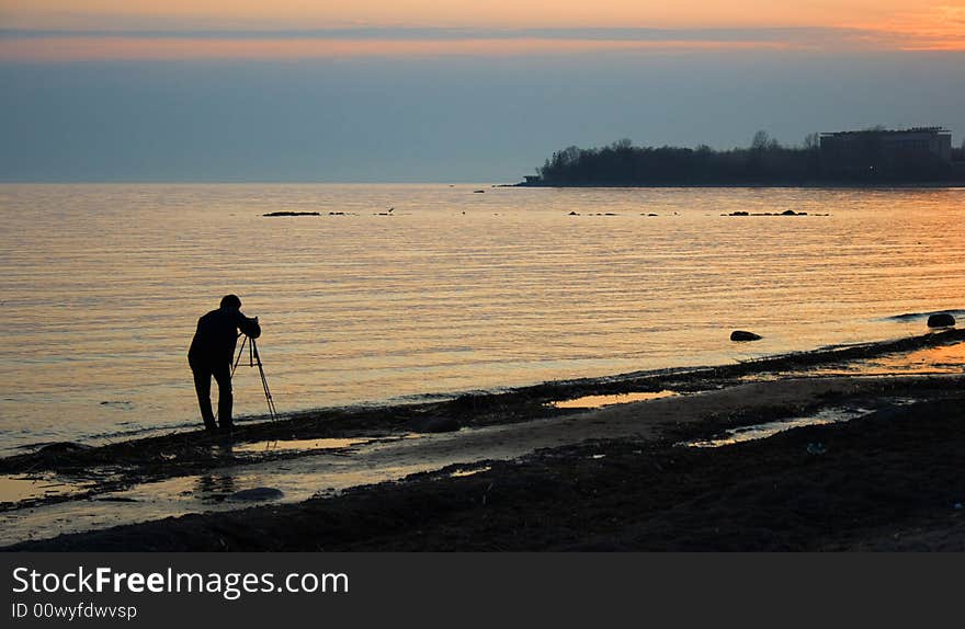 The man making photo of a sea landscape. The man making photo of a sea landscape