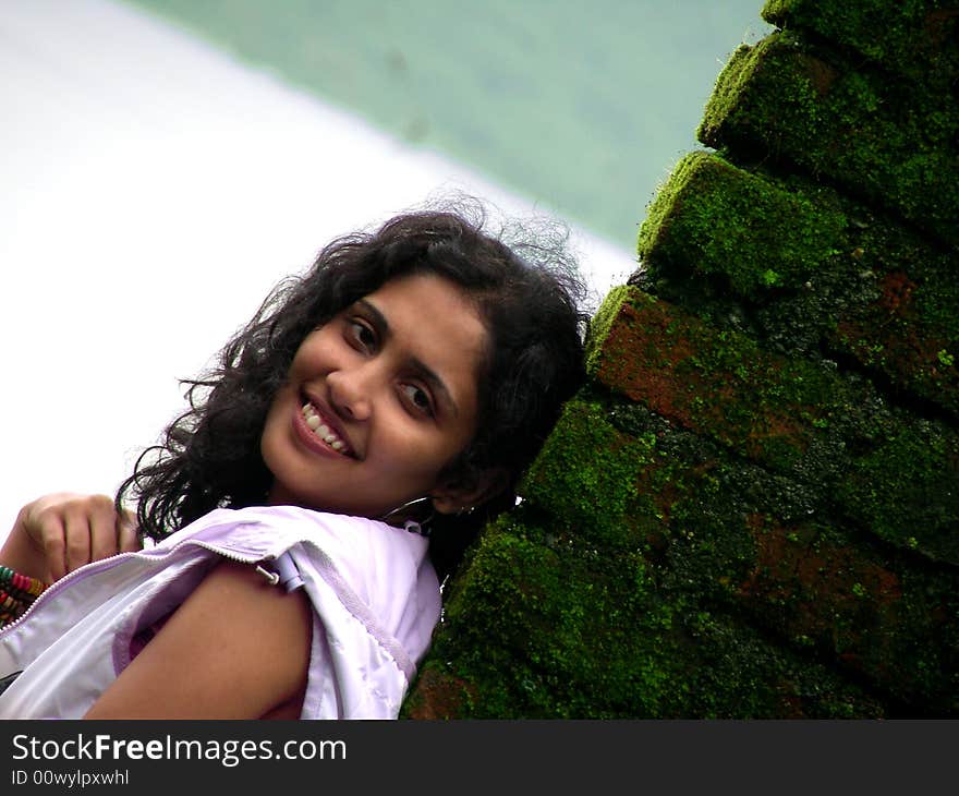 Indian Beauty at the lake side, posing by the bricks filled with moss