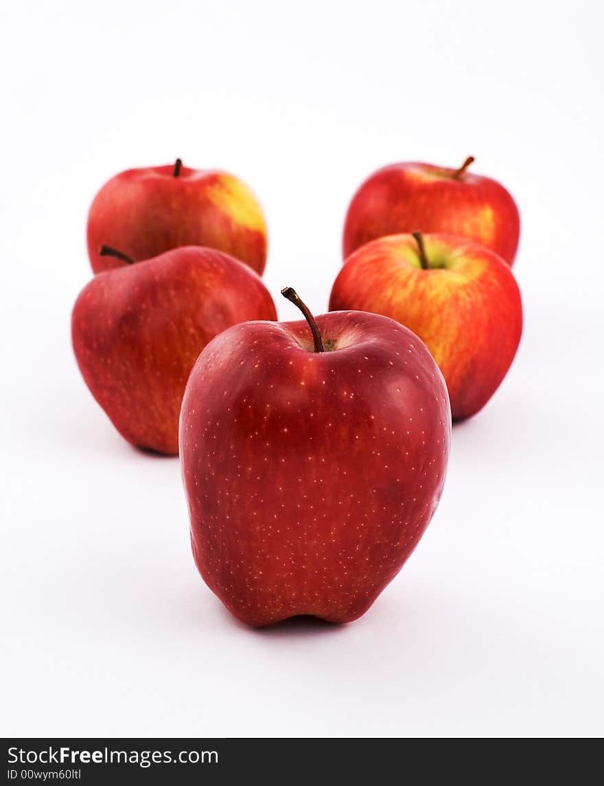 Five apples on white background with shallow depth of field