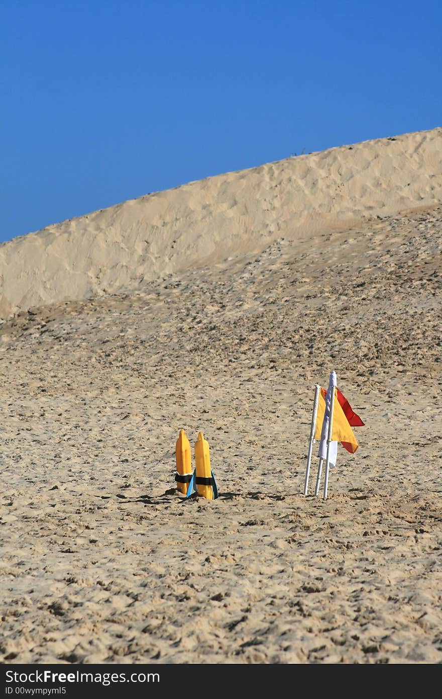 Life guard flags and life saving flotation device on the beach. Life guard flags and life saving flotation device on the beach