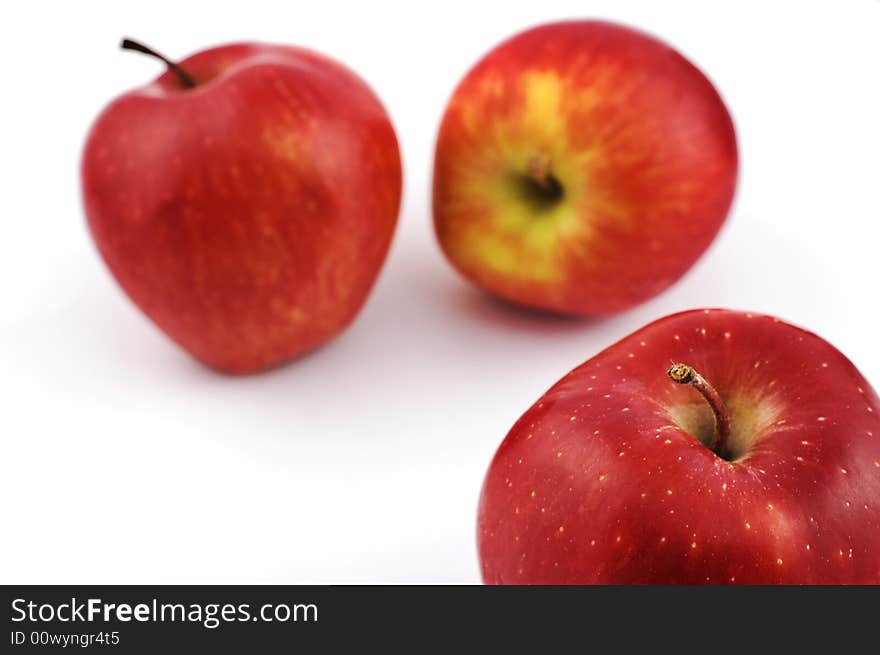 Three apples on white background with shallow depth of field