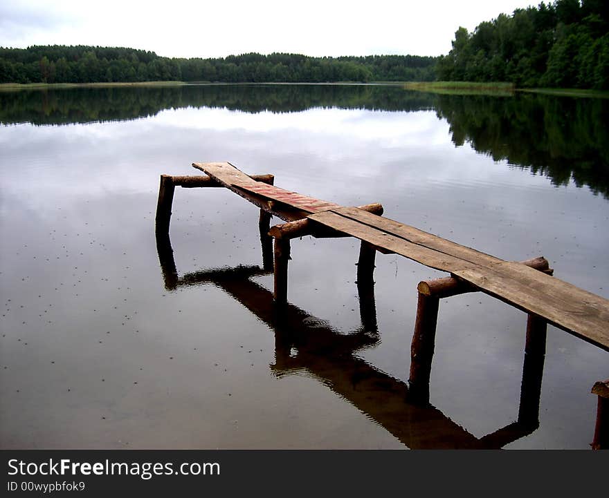 Old wooden pier on a  lake in the evening