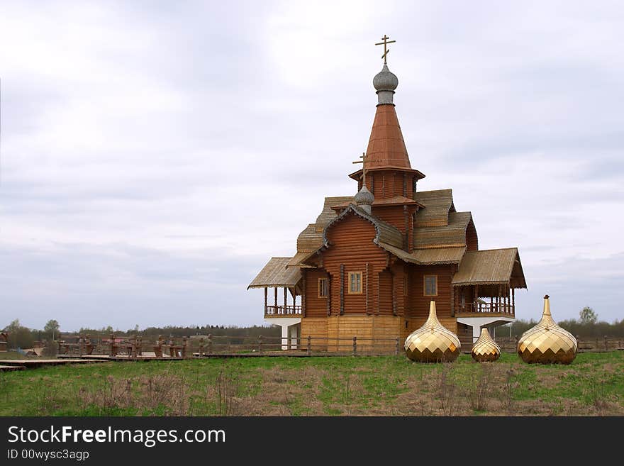 Three golden dome on the ground near wooden chapel