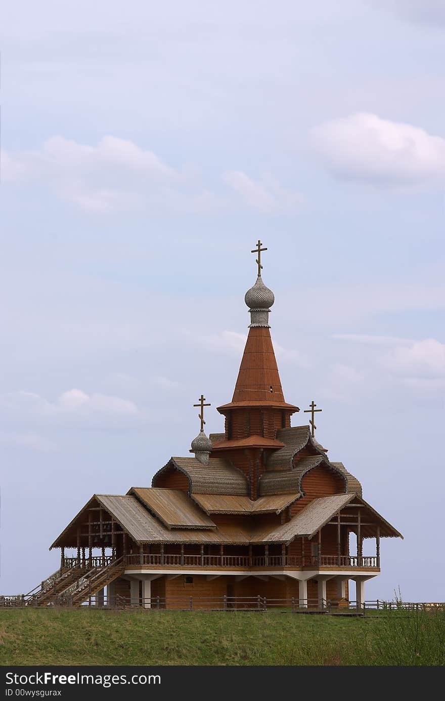 Small wooden church over blue sky with clouds. Small wooden church over blue sky with clouds