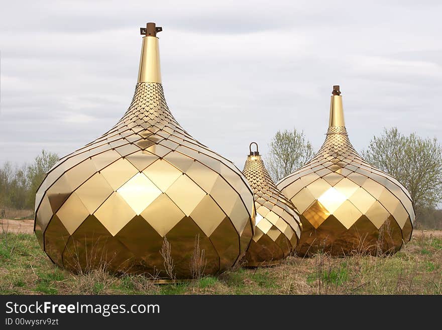 Three golden dome on the ground over blue sky