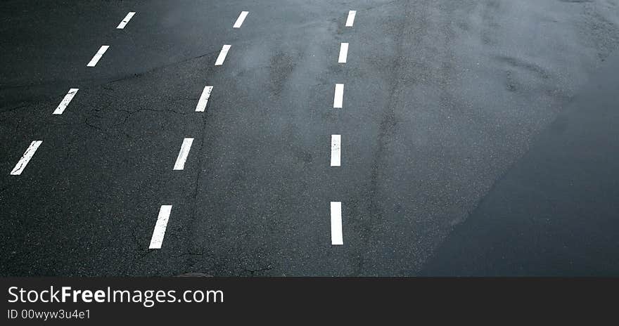 Traffic lines on asphalt showing three lanes