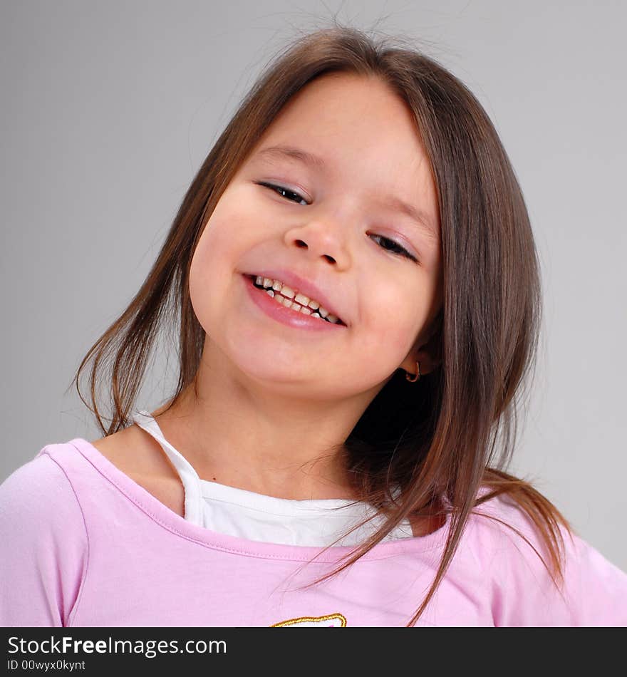 Portrait of a cute smiling cheerful baby girl with long brown hair. Portrait of a cute smiling cheerful baby girl with long brown hair