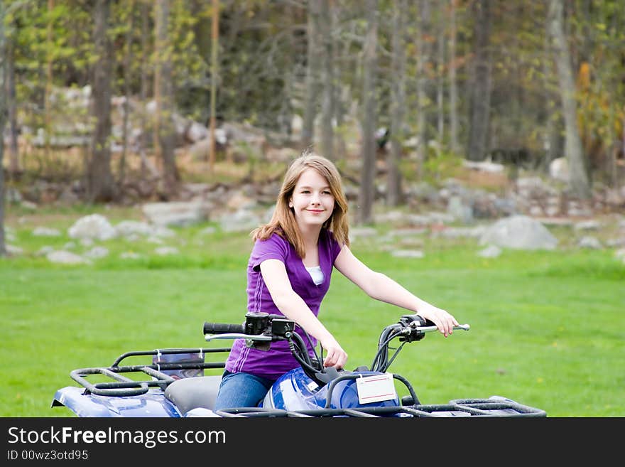 A girl sitting on her 4 wheeler. A girl sitting on her 4 wheeler