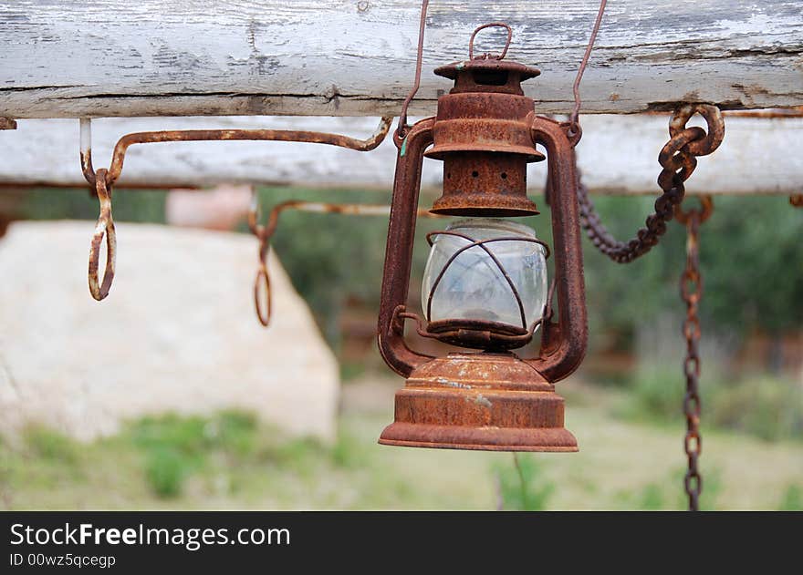 View of a rusty oil lamp hanging on a western carriage. View of a rusty oil lamp hanging on a western carriage