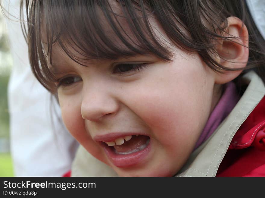 Little girl is crying outdoors in spring park