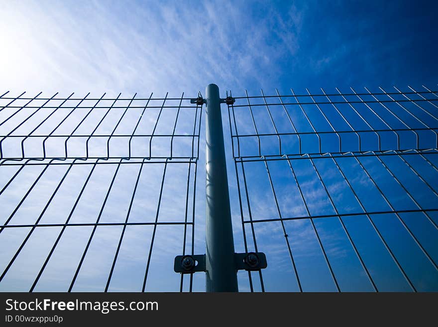 Wire link fence with a blue sky. Wire link fence with a blue sky