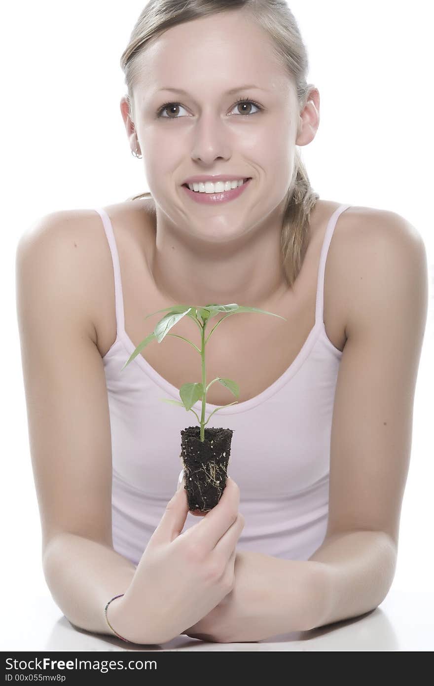 Young woman holding young sprout in the hands.