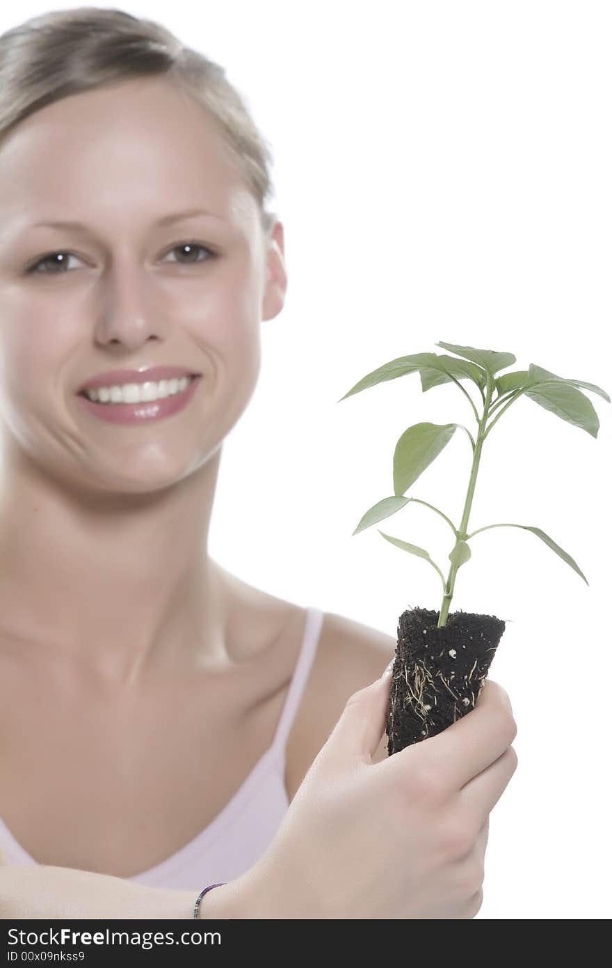 Young woman holding young sprout in the hands.