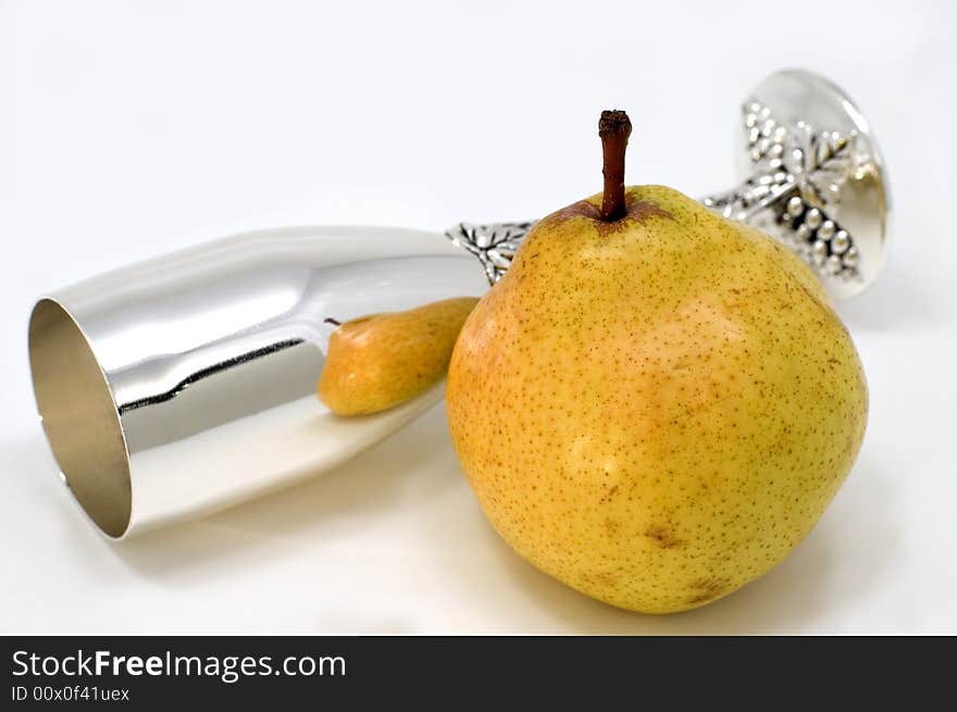 White glass and green pear on a white background.