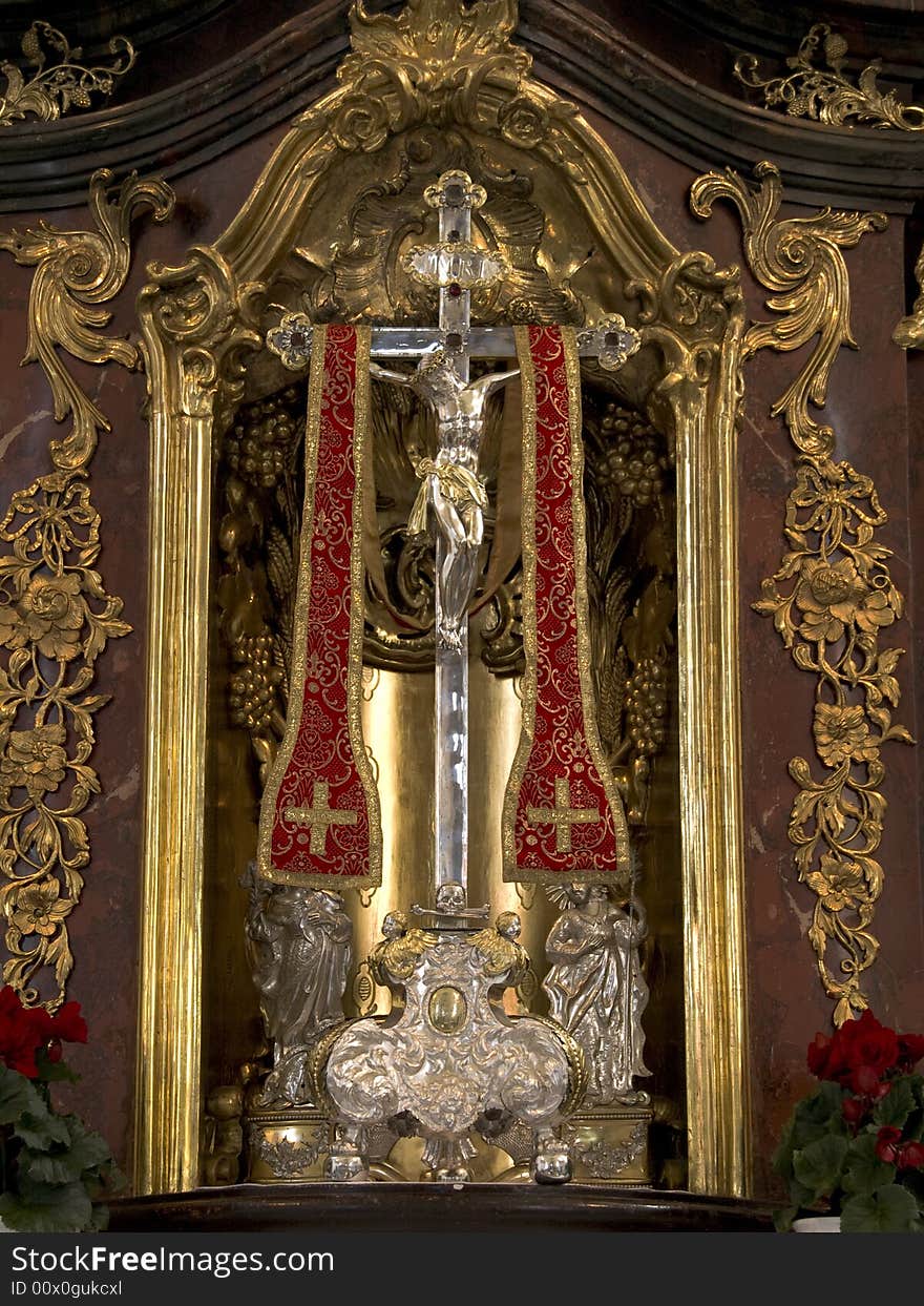 Silver crucifix on an altar decorated with golden ornaments. Silver crucifix on an altar decorated with golden ornaments