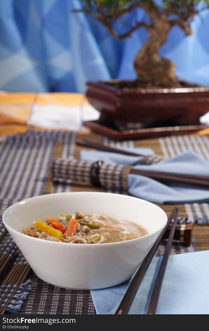 Asian style decorated table, soup bowl in the foreground