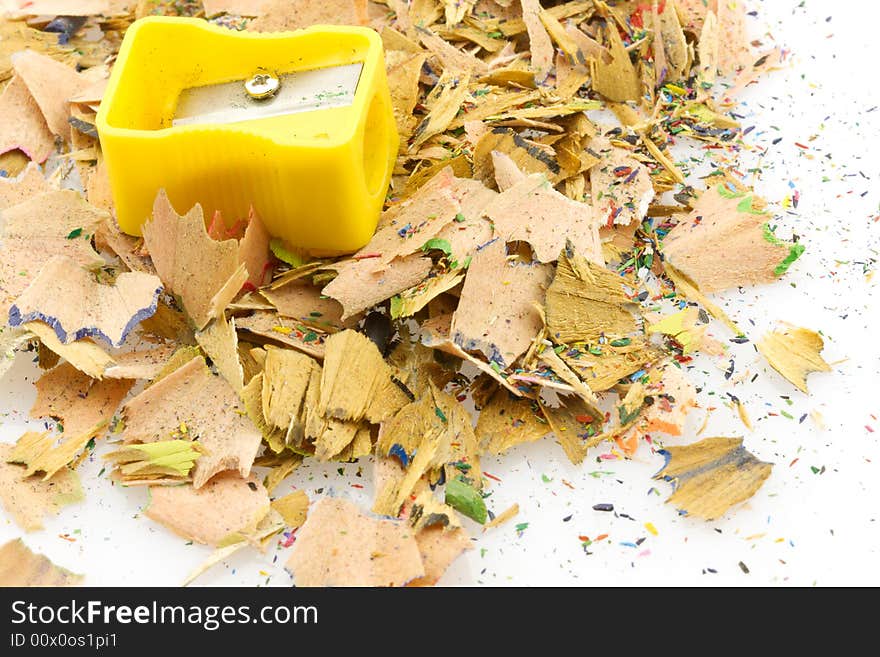 Yellow pencils sharpener on a pile of shavings, is