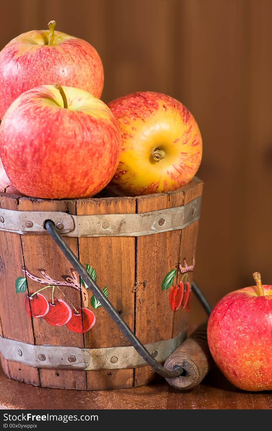 Fresh apples in bucket against wooden background