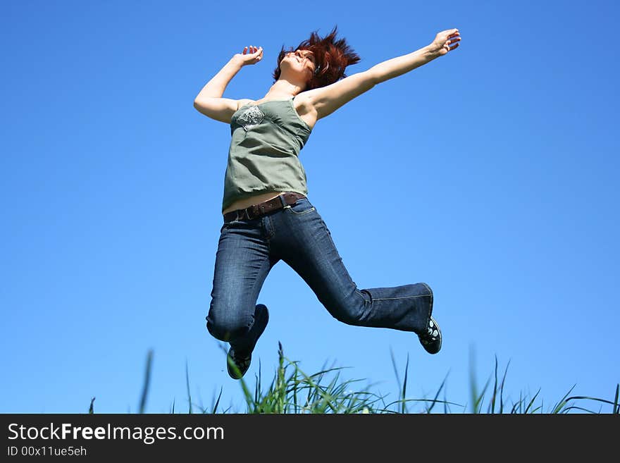 Young girl jumping on a grass. Young girl jumping on a grass