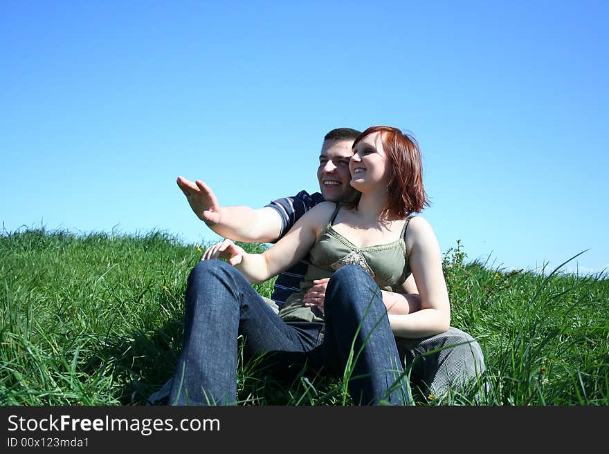 Young couple sitting on the grass. Young couple sitting on the grass