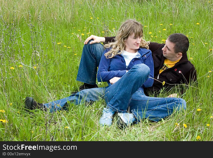 Girl and guy lay on a grass and look against each other. Girl and guy lay on a grass and look against each other