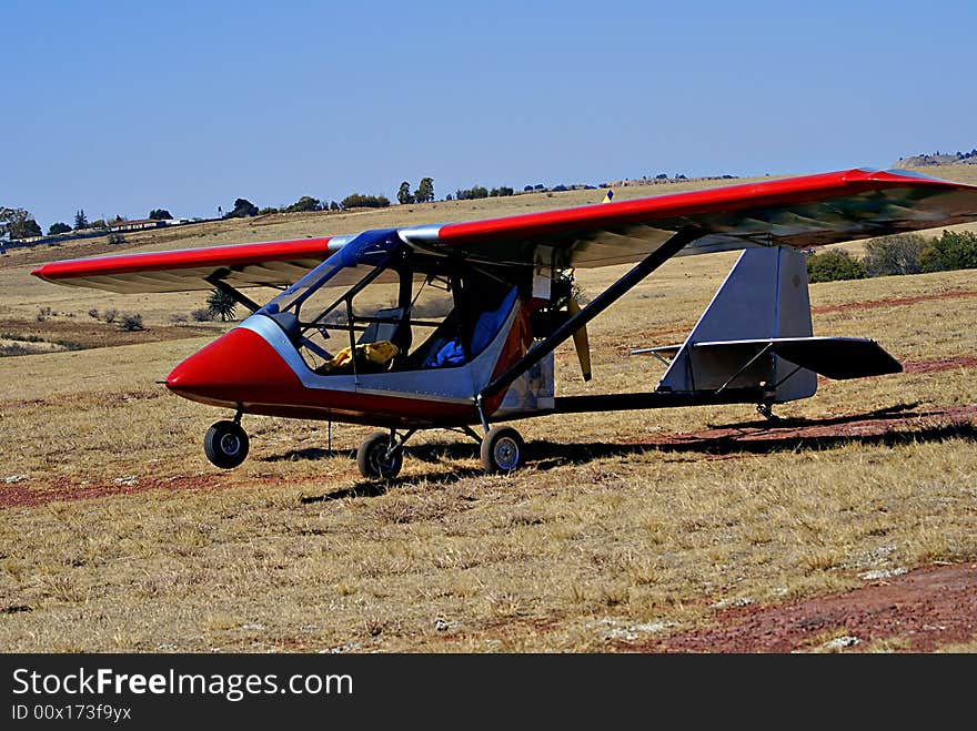 Light aircraft [Challenger microlight] parked on the side, out of the hub bub during an air show